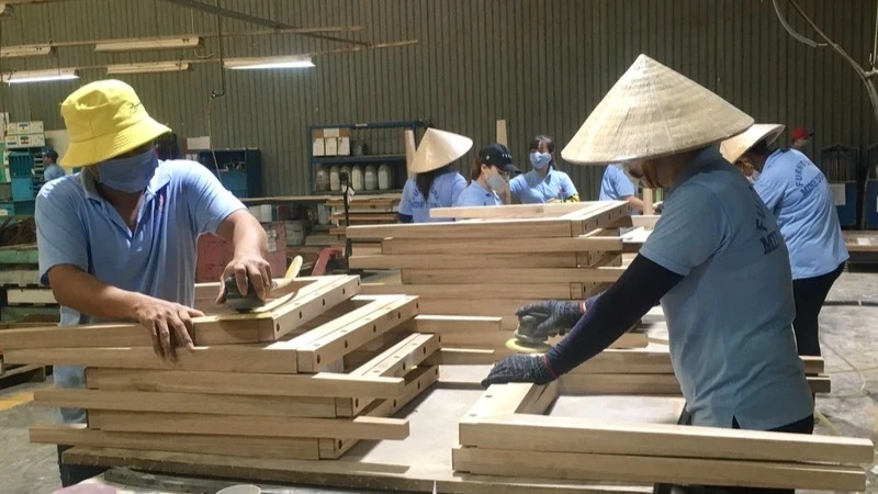 Producing wooden furniture for export. (Photo: Dung Minh)