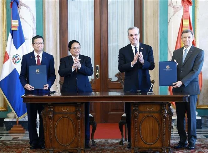 Prime Minister Pham Minh Chinh (second from left) and President of the Dominican Republic Luis Abinader Corona witness the signing of the Memorandum of Understanding on cooperation between the Diplomatic Academy of Vietnam and the Diplomatic and Consular of the Dominican Republic. (Photo: VNA)