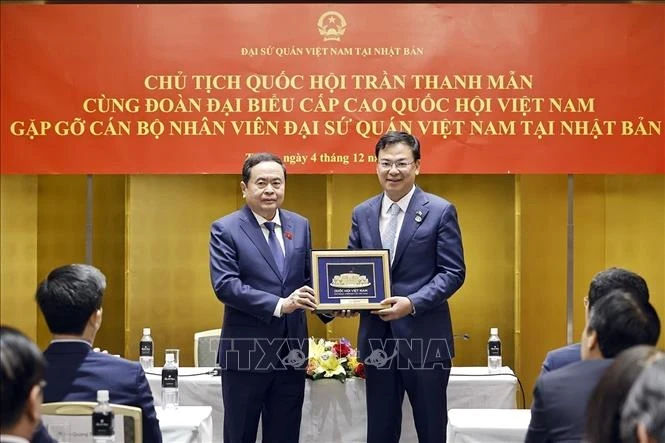 NA Chairman Tran Thanh Man presents a gift to a representative of the Vietnamese Embassy in Japan. (Photo: VNA)