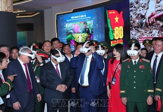 Prime Minister Pham Minh Chinh (second from left) visits the defence product exhibition area of ​​Viettel on December 19. (Photo: VNA)