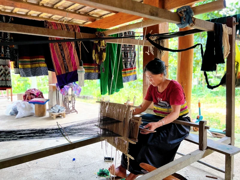 The daily work of Vi Thi Doanh (in Ngam Village, Son Dien Commune) includes weaving brocade and serving tourists.