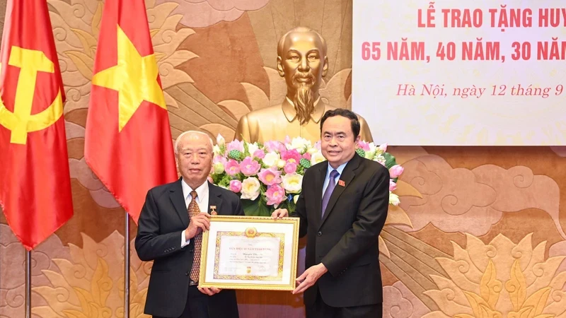 Politburo member, Secretary of the Party Delegation to the National Assembly (NA) and NA Chairman Tran Thanh Man (R) presents the 65-year Party membership badge to Nguyen Van An, former Politburo member and former Chairman of the NA. (Photo: NDO)