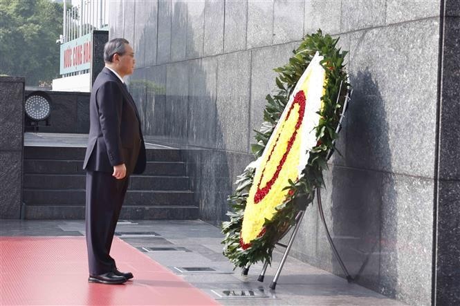 Chinese Premier Li Qiang pays tribute to President Ho Chi Minh at the Vietnamese late leader's mausoleum in Hanoi. (Photo: VNA) 