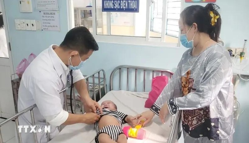 A doctor is treating a baby infected with measles (Photo: VNA)