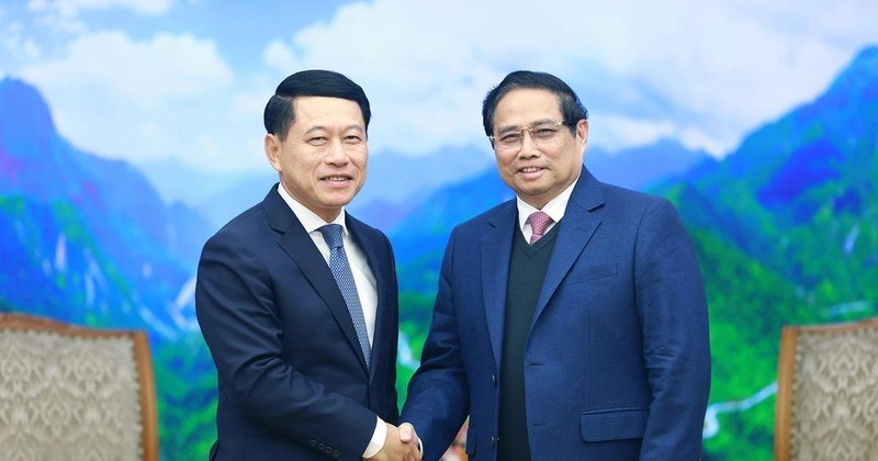 Prime Minister Pham Minh Chinh (R) receives visiting Lao Deputy Prime Minister Saleumxay Kommasith in Hanoi on December 30. (Photo: VNA) 