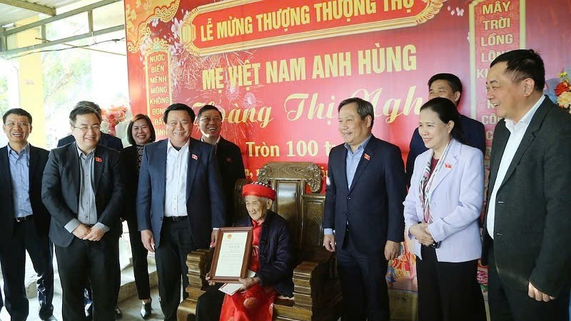 Politburo Member Nguyen Xuan Thang presents a congratulatory card from the President of Vietnam to Heroic Vietnamese Mother Hoang Thi Nghi on the occasion of her 100th birthday.