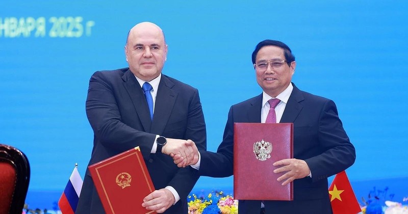 Prime Minister Pham Minh Chinh (R) and his Russian counterpart Mikhail Vladimirovich Mishustin sign a joint communiqué on the results of the Rusian PM's official visit to Vietnam. (Photo: VNA) 