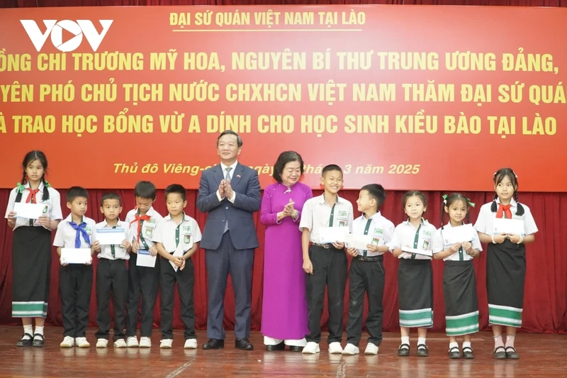 Chairwoman of the Vu A Dinh Fund Truong My Hoa and Vietnamese Ambassador to Laos Nguyen Minh Tam present scholarships to overseas Vietnamese students. (Photo: VOV)