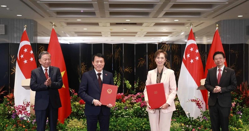 Party General Secretary To Lam (L) and Singaporean PM Lawrence Wong (R) witness the exchange of a MoU on digital transformation between the Vietnamese Ministry of Public Security and the Singaporean Ministry of Digital Development and Information on March 12. (Photo: VNA) 