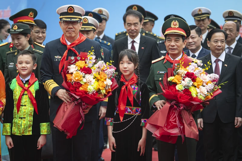 Students present flowers to the two defence ministers. (Photo: NDO)