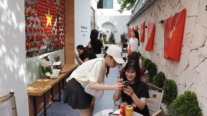 Tourists excitedly "check-in" at a coffee shop in Hanoi. (Photo: NDO)