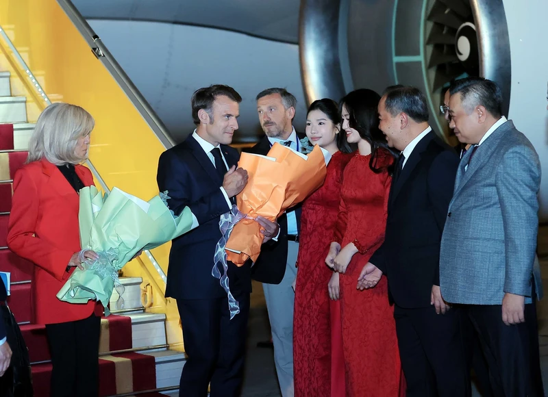 French President Emmanuel Macron and his spouse Brigitte Macron are welcomed at Noi Bai International Airport in Ha Noi on May 25 evening. (Photo: VNA)