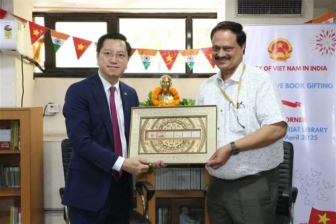 Ambassador Nguyen Thanh Hai (left) presents the representative of the Indian Central Secretariat Library with a picture of Vietnamese stamps. (Photo: VNA)