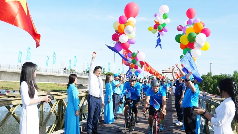 Athletes cycling through the Hien Luong bridge national historical relic site.