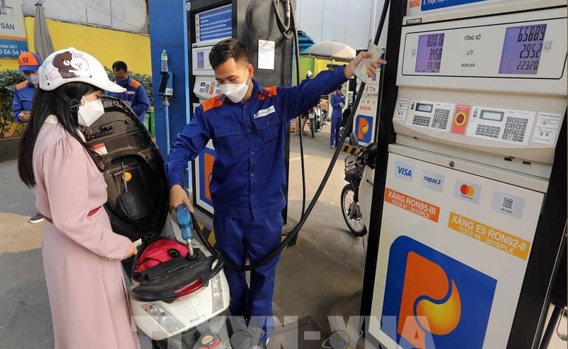 A customer buys petrol at a petrol station in Hanoi. The retail prices of E5RON92 bio-fuel and all petrol products decrease from 3pm on July 11 (Photo: VNA)