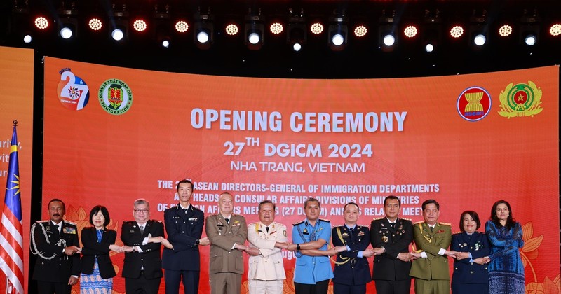 ASEAN directors-general of immigration departments and heads of consular affairs divisions hold hands at the event. (Photo: VNA)