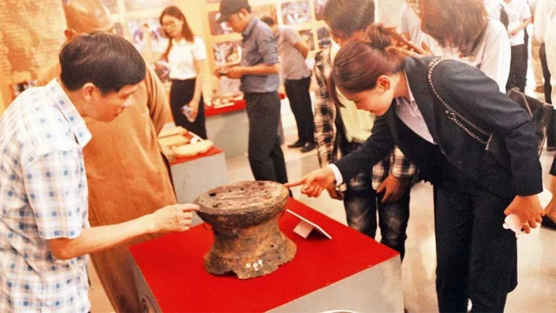 Photo: Visitors view the national treasure Tien Noi 1 Bronze Drum at Ha Nam Museum.