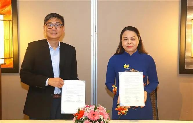 Vice Chairwoman and General Secretary of the VFF Central Committee Nguyen Thi Thu Ha (R) and Chief Executive Director of the People’s Association (PA) of Singapore Jimmy Toh exchange the MoU. (Photo: VNA)