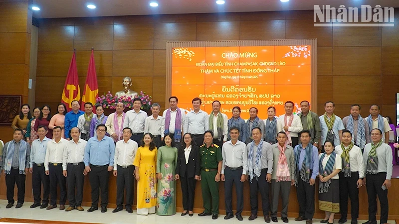 Provincial leaders of Dong Thap take souvenir photos with the delegation from Champasak Province (Laos). (Photo: HUU NGHI)