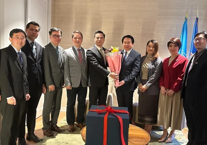 From left: Ambassador Dang Hoang Giang (5th), head of Vietnam's permanent mission to the United Nations (UN), presents a gift to Ambassador Anouparb Vongnorkeo, Lao Permanent Representative to the UN. (Photo: VNA)