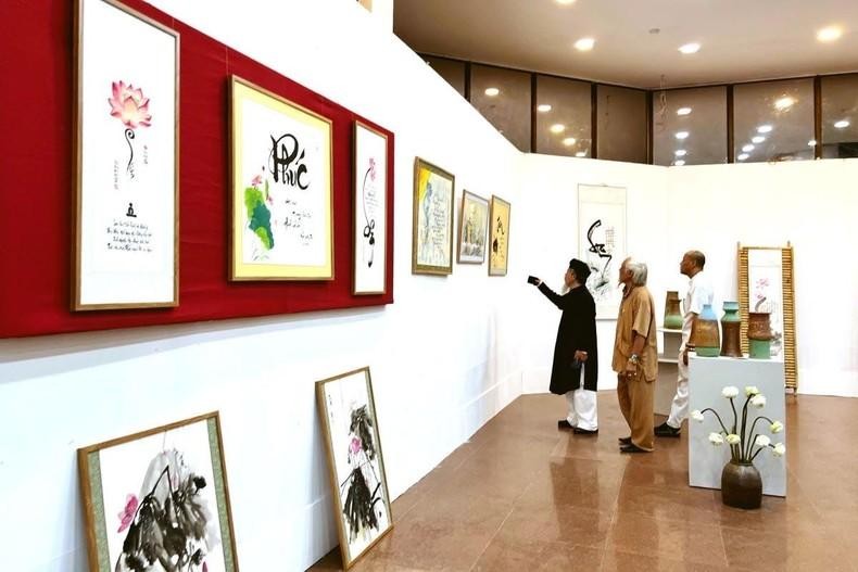 Visitors admire calligraphic works on the lotus on display at the art space.
