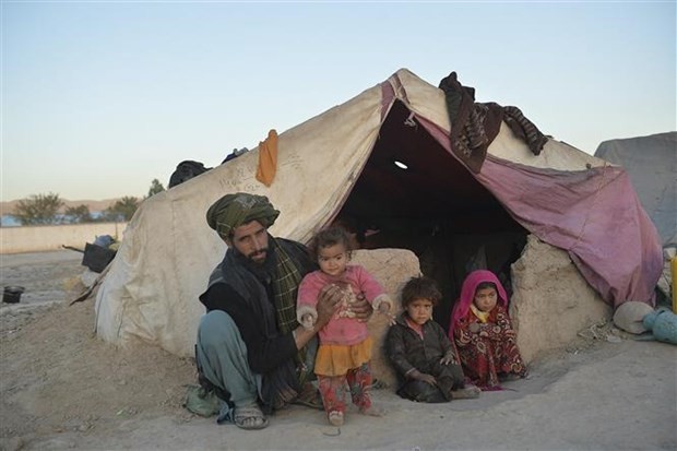 People outside a tent at the Shamal Darya Internally Displaced People (IDP) camp in Qala-i-Naw, Badghis Province, Afghanistan. (Photo: AFP/VNA)