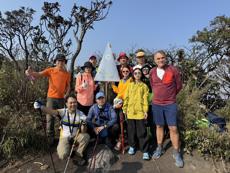 Trekkers pose for a group photo with the stainless steel pyramid on Mount Putaleng 