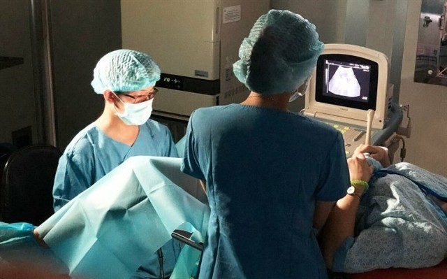 Dr. Ho Ngoc Anh Vu (left), 34, head of HCM City-based My Duc Hospital’s Fertility Support Department, performs a surgery on a patient. (Photo courtesy of My Duc Hospital)