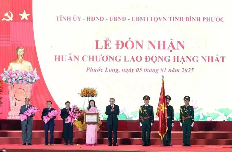 Party General Secretary To Lam (the 4th from the right) presents the first-class Labour Order - the noble honour of the State - to the Party Organisation, authorities, and people of Phuoc Long township. (Photo: VNA)