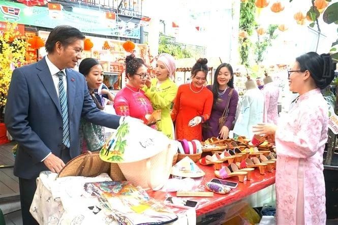 Vietnamese Ambassador to Malaysia Dinh Ngoc Linh (L) visits a booth at the event (Photo: VNA)