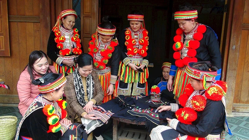 Dao ethnic women in Ban Cuon Village, Ngoc Phai Commune, Cho Don District, introduce traditional products to visitors (Photo: HUONG LIEU) 