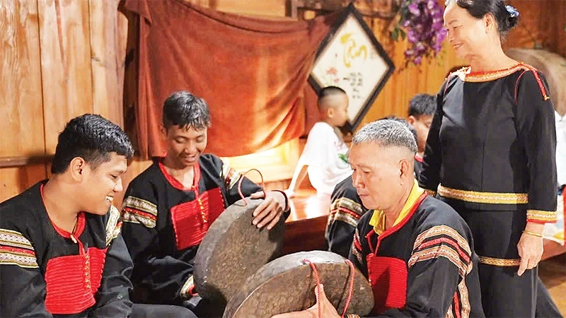 Mi Bung (standing) always encourages her villagers in Ea Tieu Commune to preserve traditional culture.