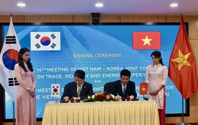 Vietnamese Minister of Industry and Trade Nguyen Hong Dien (R) and Korean Minister of Trade, Industry and Energy Ahn Dukgeun sign cooperation documents in the meeting. (Photo: VNA)
