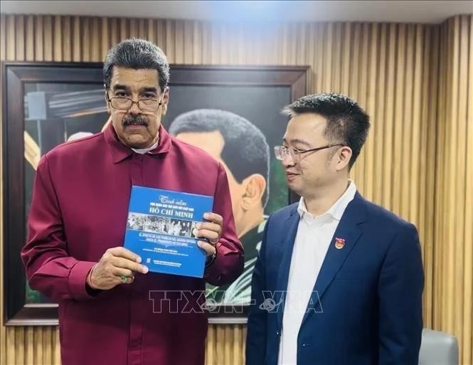 Venezuelan President Nicolas Maduro receives the Spanish edition of "The world's affection for President Ho Chi Minh" from Nguyen Tuong Lam, Secretary of the Ho Chi Minh Communist Youth Union Central Committee. (Photo: Vietnamese Embassy in Venezuela)