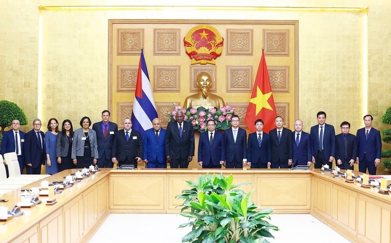 PM Pham Minh Chinh (8th from right), President of the National Assembly of People's Power of Cuba Esteban Lazo Hernandez (9th from right), and officials of the two countries pose for a group photo at the meeting in Hanoi on July 24. (Photo: VNA)