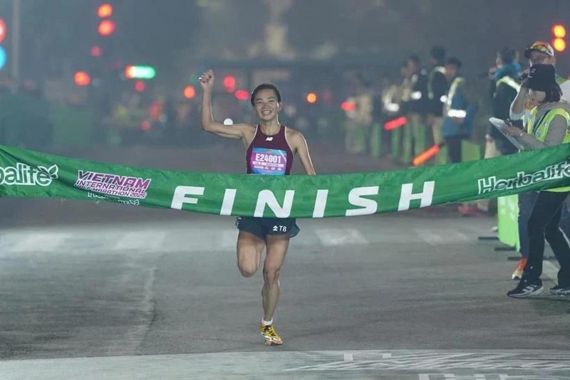 Nguyen Thi Oanh crosses the finish line in a new national record time for the women's 21km category in the Vietnam International Half Marathon 2025 powered by Herbalife on January 1 in Hanoi. (Photo: VIHM)