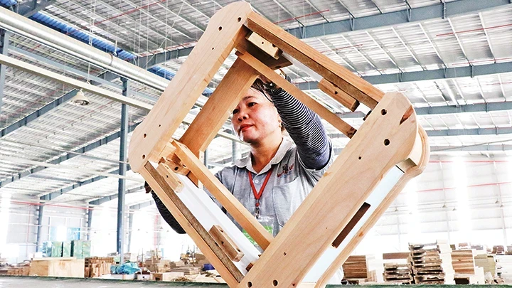 Producing wooden furniture for export to the US market at Trieu Phu Loc Company (Binh Duong Province). (Photo: VNA)