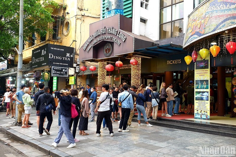 Foreign tourists queue to buy tickets for water puppet shows in Hanoi. (Photo: NDO)