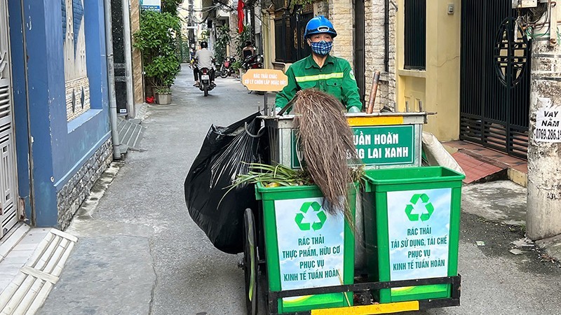 An environmental worker in Hai Phong is collecting waste. (Photo: Trung Kien)