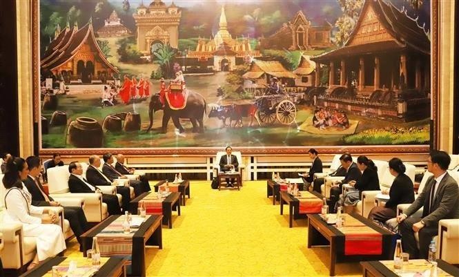 At the February 14 meeting between Lao Prime Minister Sonexay Siphandone and a delegation of Vietnamese businesses and international enterprises from various countries. (Photo: VNA)