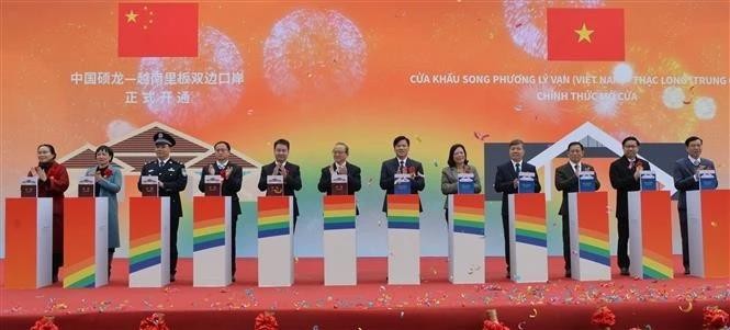Leaders of Cao Bang province and Ha Lang district, along with representatives of Daxin county (China), press the button to inaugurate the Ly Van – Shuo Long border gate. (Photo: VNA) 