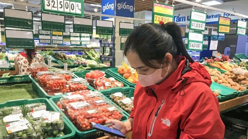 A consumer checks the origin of products at a supermarket in Buon Ma Thuot, Dak Lak Province. (Photo: Do Lan)