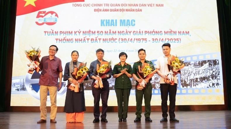 A leader of the People's Army Cinema presents flowers to film makers.