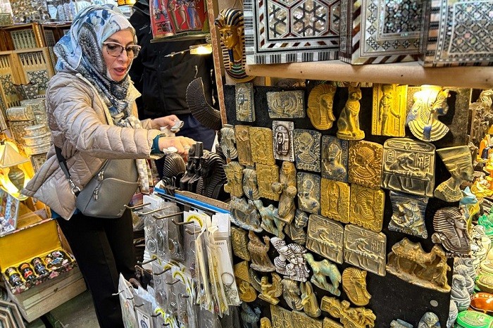 A tourist buys souvenirs at a store of the Khan el-Khalili historical market in Cairo, Egypt, on Jan. 6, 2023. Shop owners in Khan el-Khalili, one of the most famed tourist attractions in the Egyptian capital Cairo, hope for the return of Chinese guests after China announced its easing of travel restrictions starting from Jan. 8. (Photo: Xinhua)