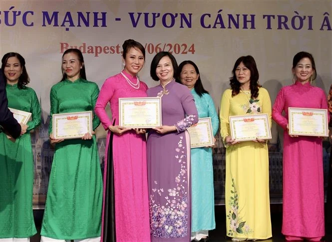 Ambassador Nguyen Thi Bich Thao presents certificates of merit to members of the Vietnamese women's union in Hungary for their contributions to its activities. (Photo: VNA)