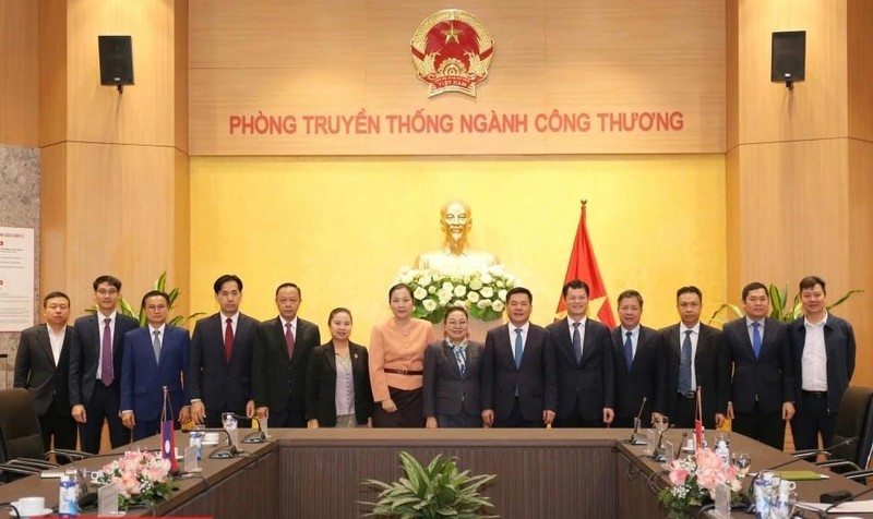 Minister of Industry and Trade Nguyen Hong Dien (6th from right) and Lao Ambassador to Vietnam Khamphao Ernthavanh (7th from right) have a working session in Hanoi on January 3. (Photo: tapchicongthuong.vn)