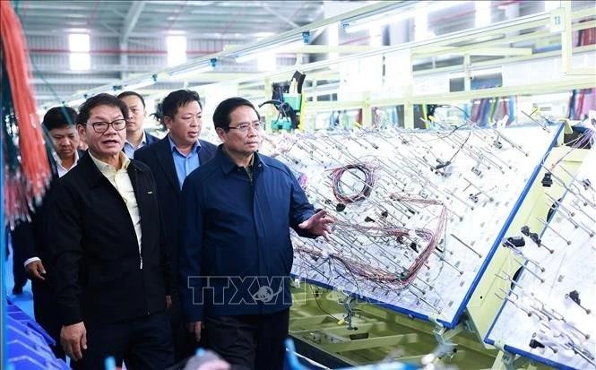 Prime Minister Pham Minh Chinh (R) visits the production line of THACO Group. (Photo: VNA)