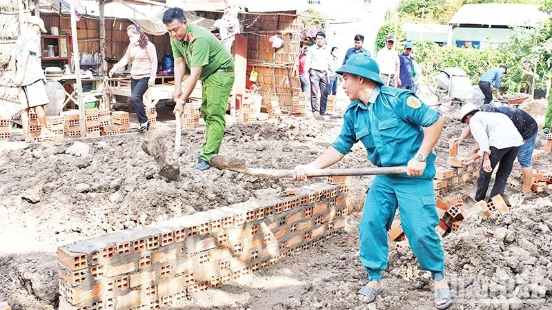 Armed forces and political organisations of Huyen Hoi Commune, Cang Long District, Tra Vinh Province, support people to build houses. (Photo: KHOI - GIANG)
