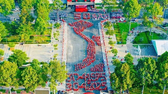 People perform an artistic formation to celebrate the 50th anniversary of the Liberation of the South and National Reunification.