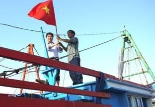 Secretary of the Ho Chi Minh Communist Youth Union Nguyen Manh Dung presenting the national flag to a fisherman in Truon